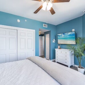A bedroom with a bed, a dresser, a ceiling fan, and a painting on the wall. - Gulf View - Amazing Sunrises (Destin)
