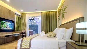 Habitación de hotel moderna con una cama grande, televisión, escritorio y vistas al exterior.