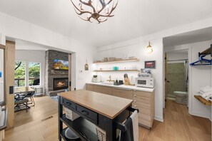 Een moderne keuken met een centraal eiland, een ingebouwde open haard en een eetgedeelte met uitzicht.
