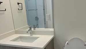 Un bagno moderno con lavandino, specchio e wc.