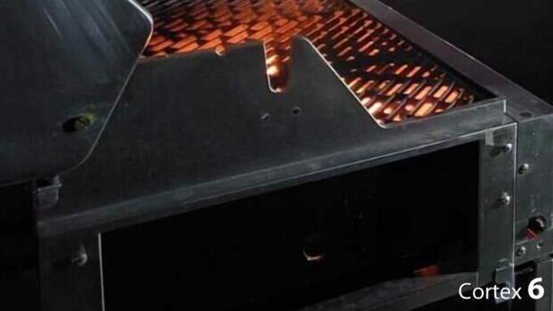 A metal structure with a grate and a view of a cityscape at night. - PRIVATTO SUITES (Saltillo)