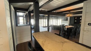 Un interior moderno con una barra alargada, asientos y vistas al exterior por una ventana.