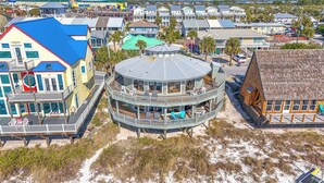 Un bâtiment situé sur la côte, doté d’une structure circulaire, de nombreux balcons et d’un emplacement en bord de plage.