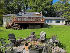 A backyard with a fire pit, outdoor furniture, and a wooden deck leading to a house. - Fall Weekends and Ski Season is here! (Stockbridge)