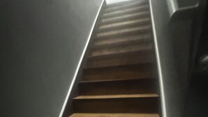 Una escalera que sube con peldaños alfombrados y detalles blancos.