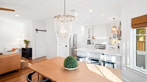 A modern kitchen with white cabinetry, a central island, and pendant lighting. - Private Pool, Coastal Cottonwood Retreat, Sleeps 13,  Beach Access (Inlet Beach)