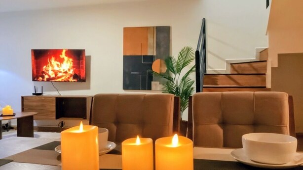 A modern living room with a fireplace, comfortable seating, and a flat-screen TV. - Casa Luma is a calm, light-filled home designed for rest and simplicity. (Aguascalientes)