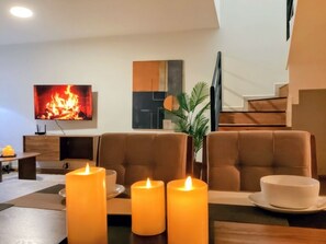 A modern living room with a fireplace, comfortable seating, and a flat-screen TV. - Casa Luma is a calm, light-filled home designed for rest and simplicity. (Aguascalientes)