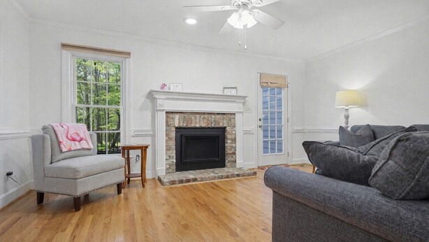 A living room with a fireplace, a ceiling fan, and a view of the outdoors. - Floating Flamingo; Walk to Downtown Cary; Greenway; Close to Cary Park; Wake Med (Cary)