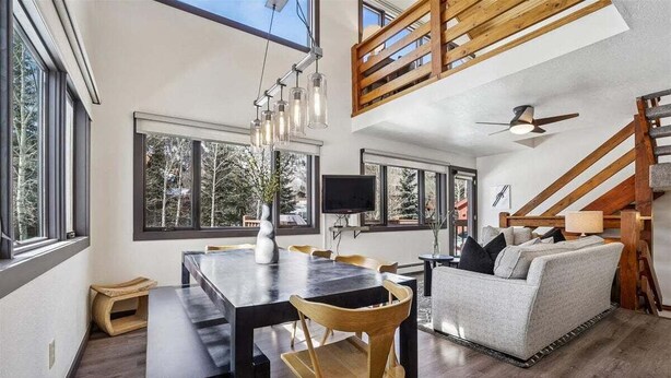 En modern inredning med ett matområde, en soffa och en trappa.