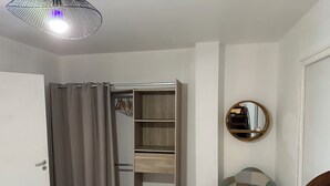 Una habitación con un armario, un espejo y una silla.