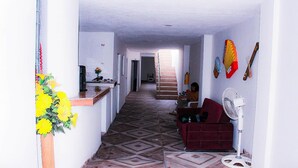 A hallway with a kitchen area on the left, a staircase in the center, and a living room area on the right. - HOTEL URUMITA MAGICA (Valledupar)
