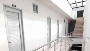 A modern interior with a metal railing, a staircase, and a door labeled "ECO". - HOTEL URUMITA MAGICA (Valledupar)