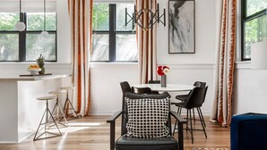 A modern dining area with a round table, black chairs, and a patterned cushion. - Designer Inman Park | Beltline Steps (Atlanta)