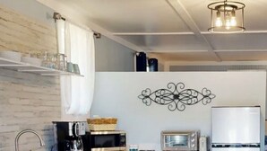 A modern kitchen with white cabinets, a stainless steel sink, a microwave, a toaster, and a refrigerator. - The Nest ~ Near Music Park + Lake Views (Live Oak)