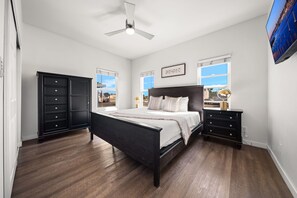 A bedroom with a bed, a dresser, a nightstand, a ceiling fan, and a TV. - Point Loma Cozy Retreat - Spa l AC l Parking (San Diego)