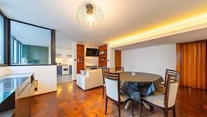 A modern kitchen with a dining area, wooden flooring, and a unique ceiling light fixture.