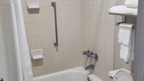 Une salle de bain équipée d’une baignoire, de toilettes, d’une douche et d’un porte-serviettes.