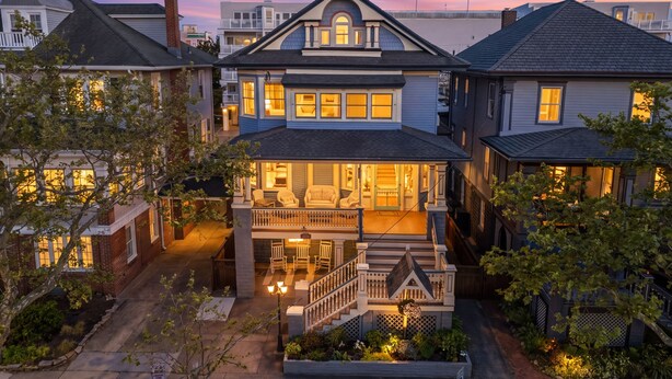 A two-story Victorian-style house with a front porch, a small garden, and a driveway. - Bayberry House- 11BR/9BA in Ocean City NJ (Ocean City)