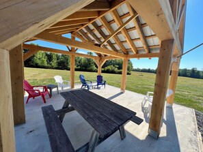 A wooden pergola with a picnic table and chairs.