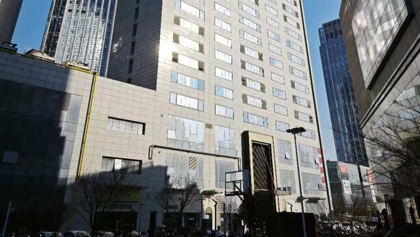 A high-rise building with multiple floors, large windows, and a prominent entrance. - XINGHEHOTEL (Xi'an)