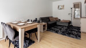 Un espacio moderno de estar con comedor, sofá y una alfombra pequeña.