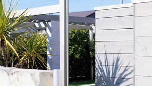 Un bâtiment moderne avec une façade blanche et un toit en métal.