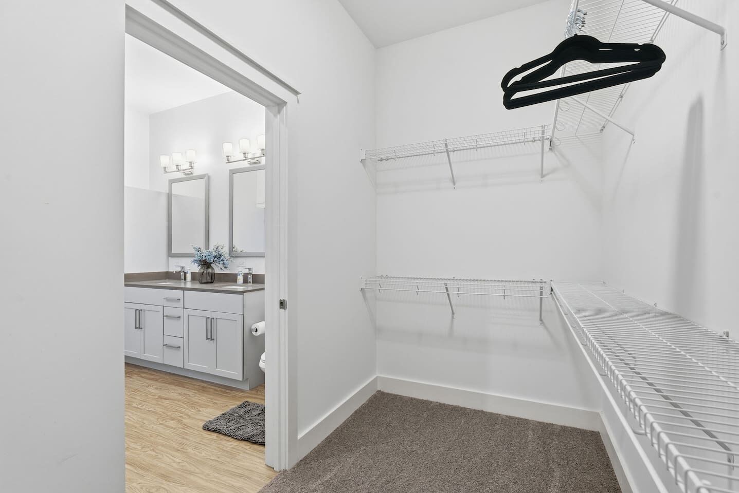 A modern bathroom with a shower, a toilet, and a sink. There is a towel rack and a mirror above the sink.