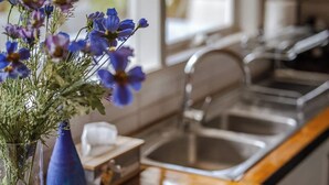 A kitchen counter with a loaf of bread, a small plate with cheese and crackers, and a vase with flowers. - Seednest Treehouse Spectacular Mountain View (Monbulk)