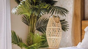 A bed with a white comforter, a woven decorative vase, and a large potted plant with green leaves. - Seednest Treehouse Spectacular Mountain View (Monbulk)