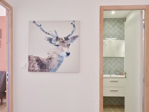 A modern bathroom with a geometric tile backsplash, a white sink, and a mirror above it. - 1-Br with Terrace – Carré d’Or, Walking Distance to the Beaches (Cannes)