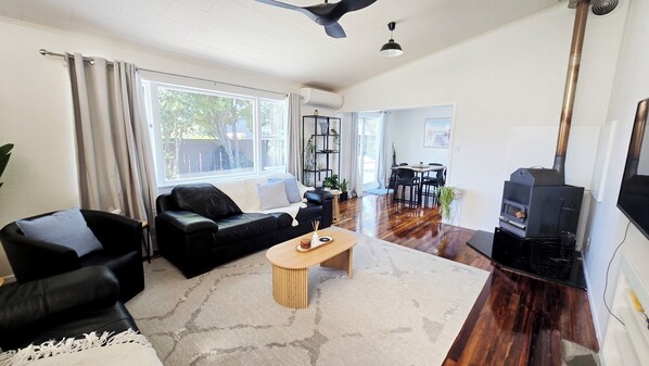 A living room with a sofa, armchair, coffee table, and a fireplace.