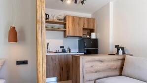 Een moderne keuken met houten kastjes, een zwarte koelkast en een kleine eettafel.