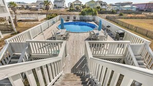 A pool area with a wooden deck, lounge chairs, and a view of surrounding houses. - Walk to Beach | Pool, Deck & Easy Gulf Shores Stay (Gulf Shores)