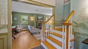 A spacious living room with a staircase leading to another level.