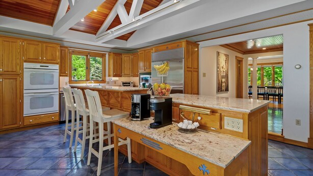 A spacious kitchen with wooden cabinets, a large island, and a built-in oven.