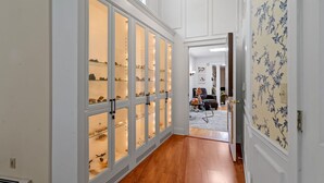 A hallway with a shoe display, a ceiling light, and a door leading to another room.