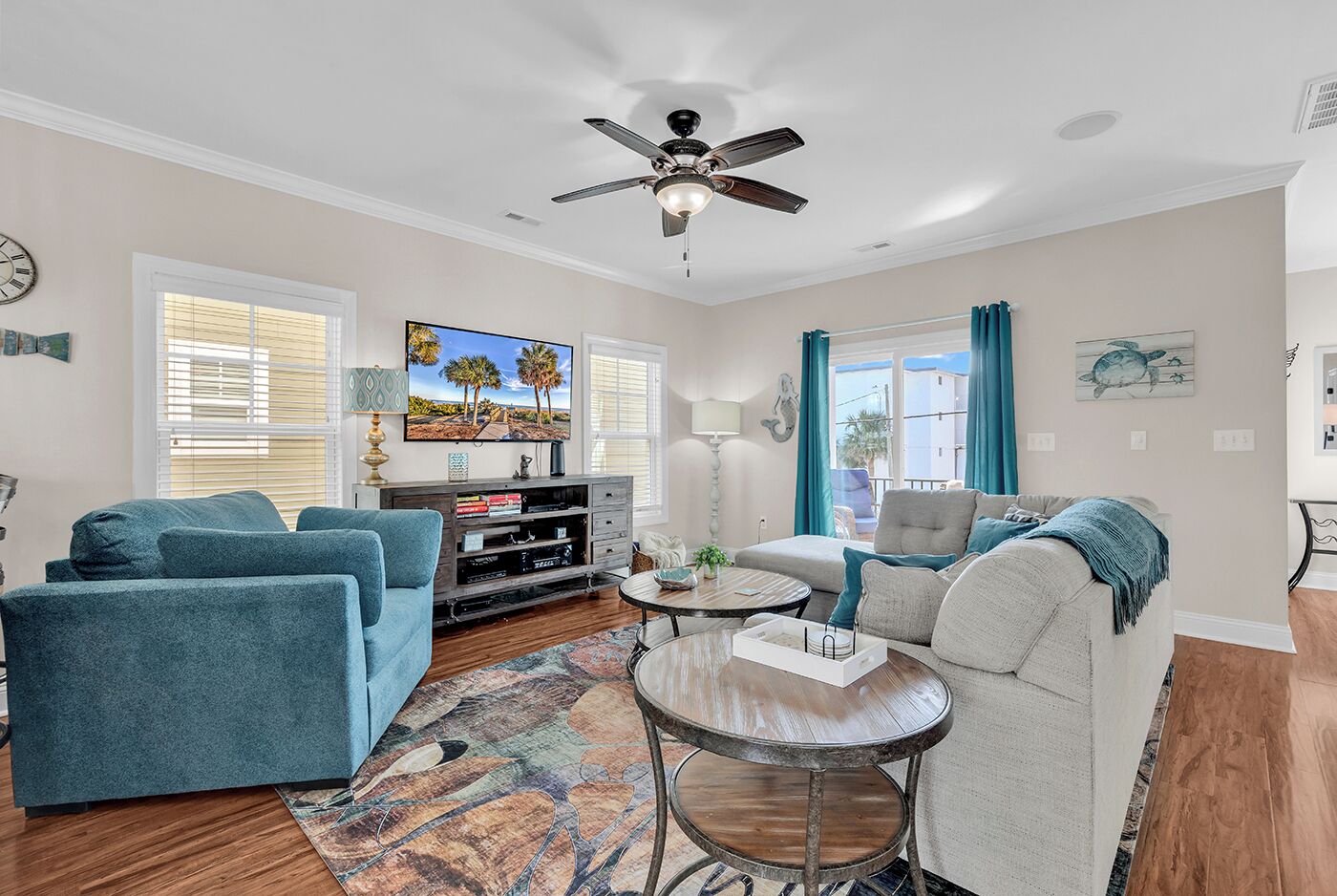 A living room with a ceiling fan, a TV, a fireplace, and a dining area with a table and chairs.