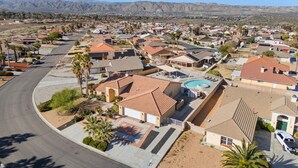 A residential area with houses, a curved road, and mountains in the background. - Casa Selecta - Hot Tub, Game Room & Pool (Yucca Valley)