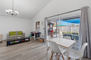 Ein modernes Wohnzimmer mit einer Couch, einem Couchtisch und einem Essbereich mit Stühlen und einem Tisch.