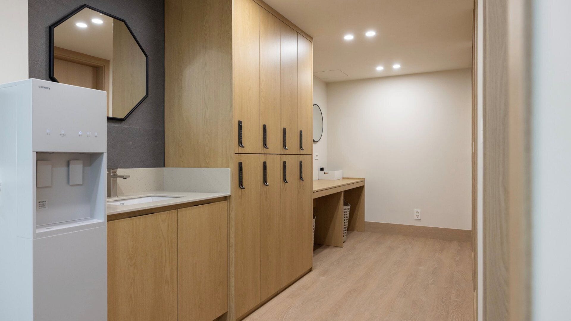 A modern bathroom with a white sink, wooden cabinets, and a mirror.
