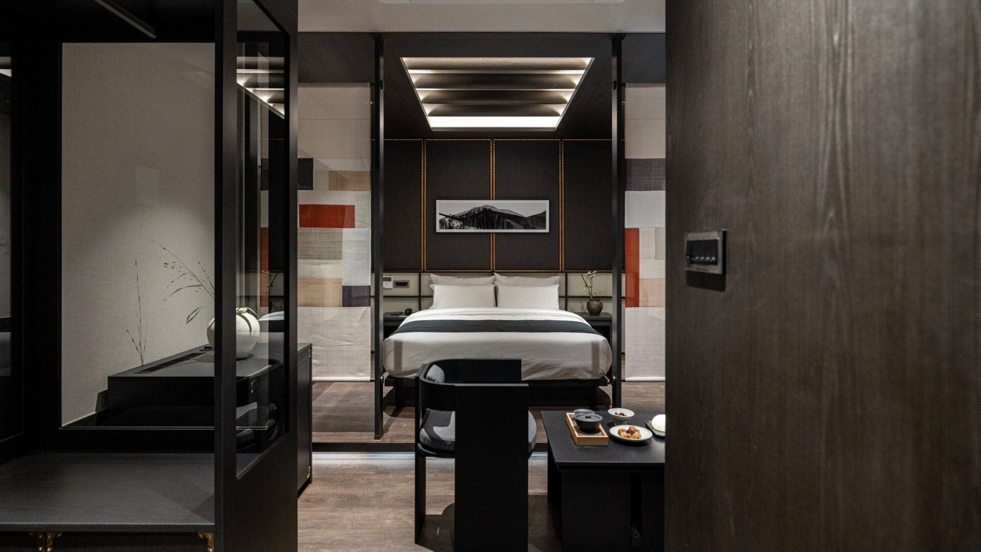Una habitación de hotel moderna con una cama grande, un escritorio y un espejo.