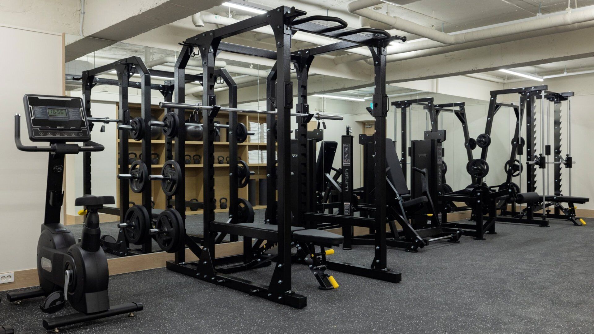 A gym with various weightlifting equipment, including barbells, weight plates, and a digital scale.
