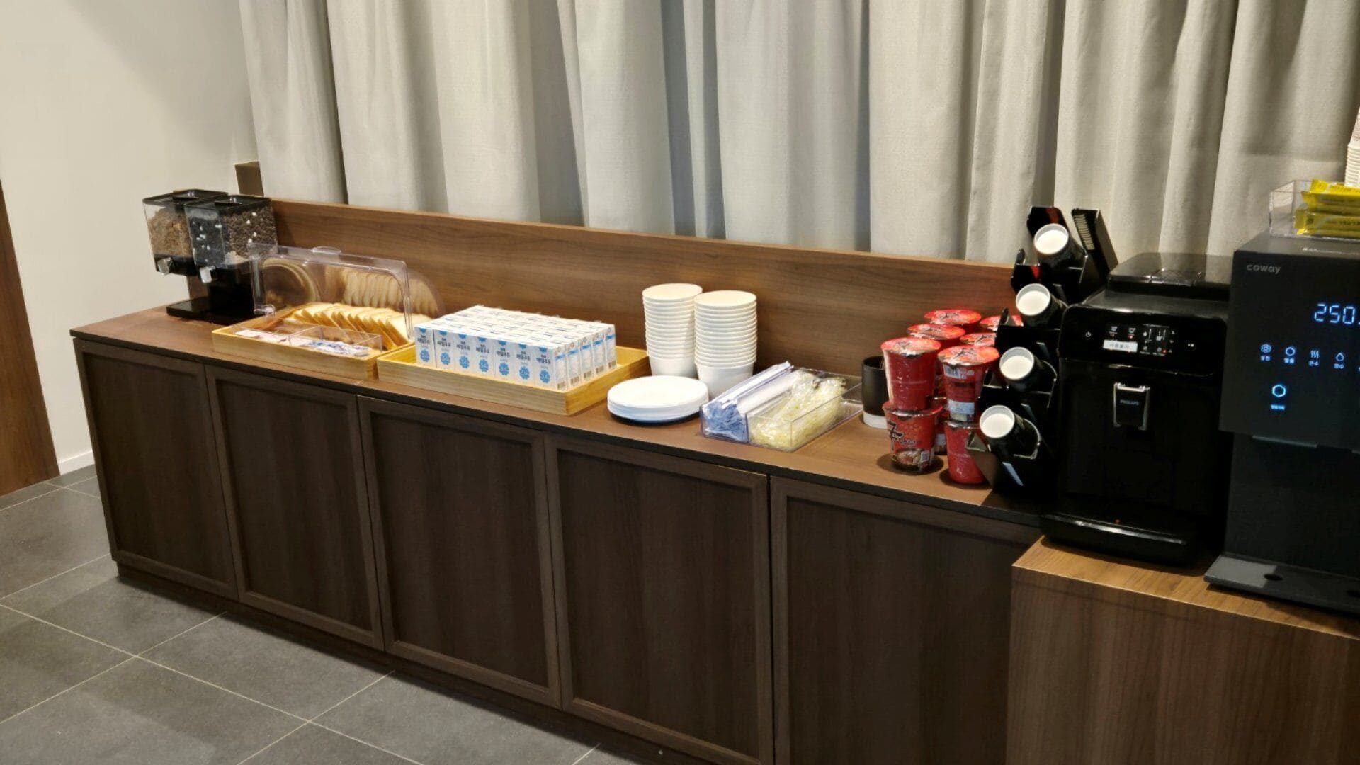 A buffet setup with various food items, plates, and condiments.