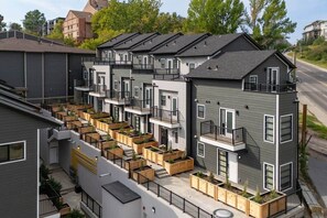 Un moderno edificio de apartamentos con varias unidades, balcones y macetas de madera.