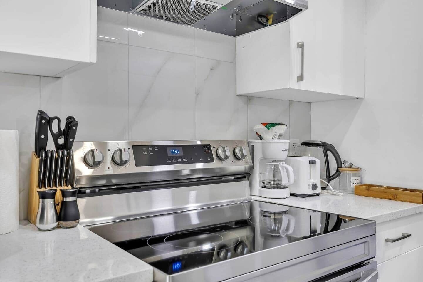 A modern kitchen with stainless steel appliances, a coffee maker, and a knife block.