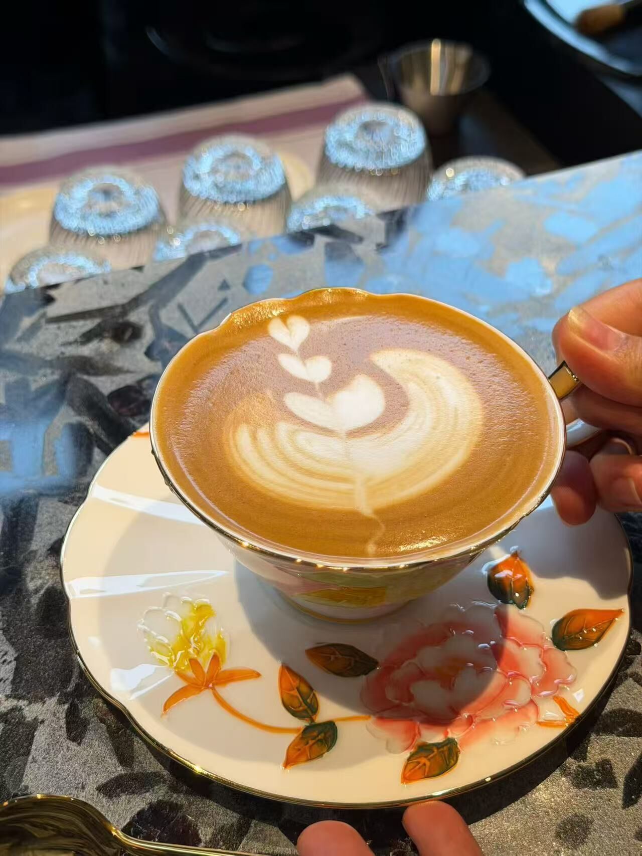 A cup of coffee with latte art on a saucer.