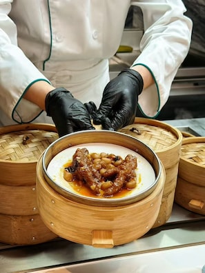 A chef preparing a dish in a bamboo steamer. - Gauss Hotel GUANGZHOU (Guangzhou)