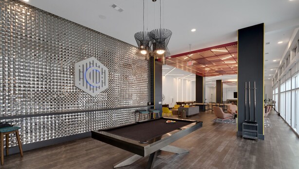 A billiards table in a modern indoor space with a patterned wall and a large window. - Luxury Midtown Apt: Pool, Gym & 4 Bedrooms! (Atlanta)