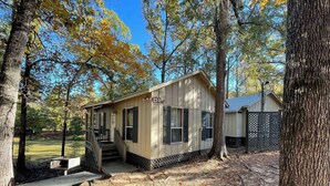 A small cabin with a porch, a picnic table, and a fenced yard. - Peaceful Cabin with Full Kitchen, Vaulted Ceilings & Pond View Porch (Zwolle)